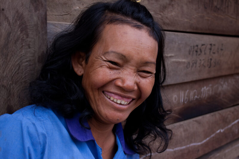 Woman in Cambodia — Woman smiles for camera as she sits in the doorway to her home in Rural Cambodia — Cambodia, Rural, woman, smile, smiles