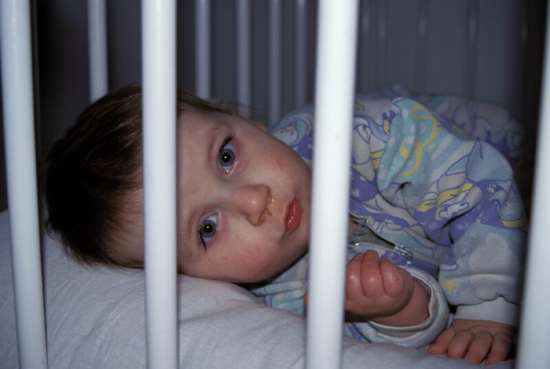 War Orphan in Bosnia — Orphan due to the Bosnian war, looks up from crib in the orphanage. — Bosnia, war, refugee, refugees, babies
