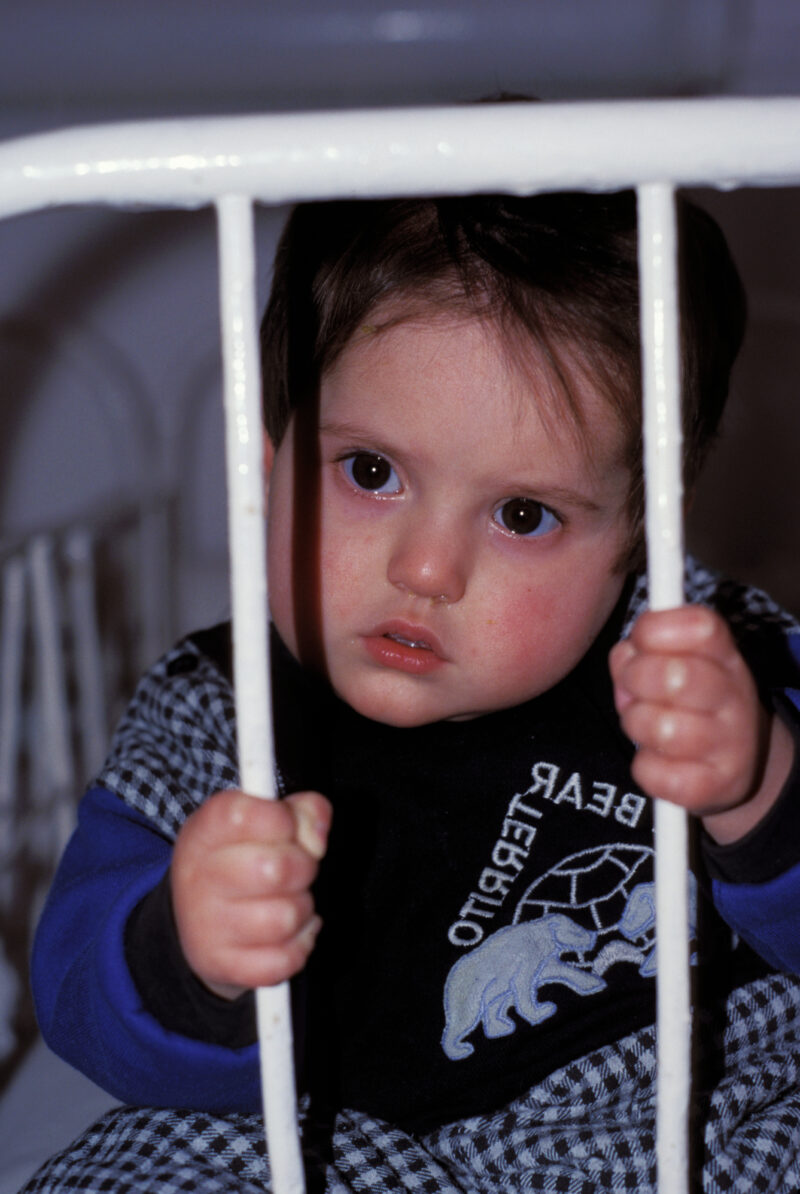 War Orphan in Bosnia — Orphan due to the Bosnian war, looks up from crib in the orphanage. — Bosnia, war, refugee, refugees, babies