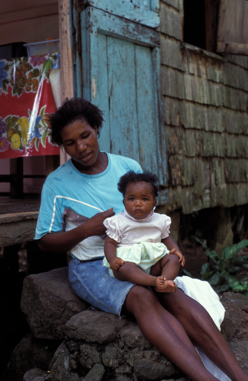 Baby in Dominica — Baby sits on mother's knee in Dominica. — Mother, Baby, babies, Dominica, Caribbean