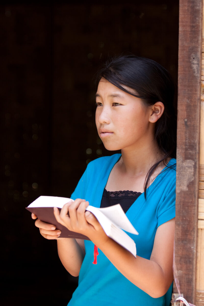 Bible Study in Laos — Woman reads the Bible in the doorway of her home in Laos — Laos, Southeast Asia, woman women, christian, ethnic