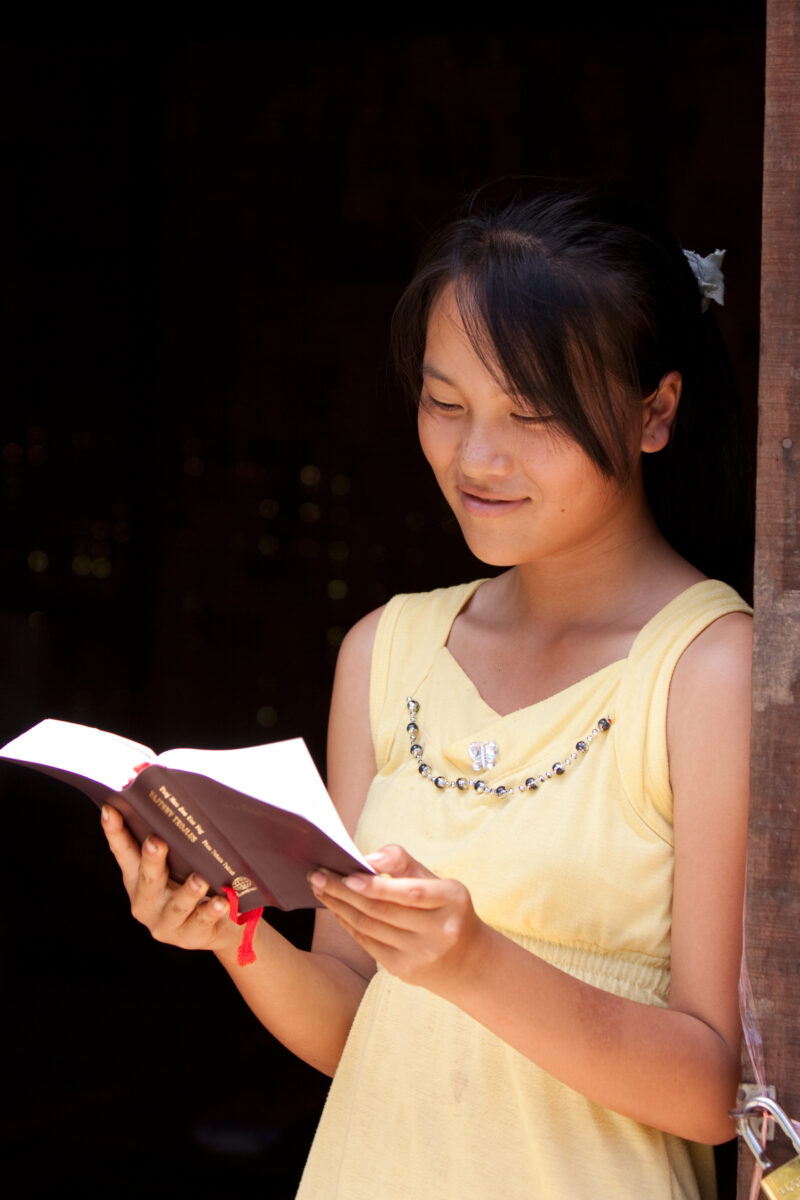 Bible Study in Laos — Woman reads the Bible in the doorway of her home in Laos — Laos, Southeast Asia, woman women, christian, ethnic