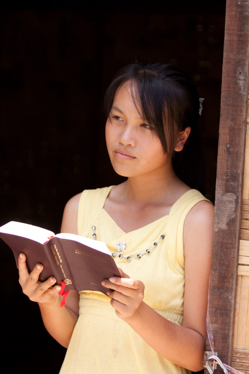 Bible Study in Laos — Woman reads the Bible in the doorway of her home in Laos — Laos, Southeast Asia, woman women, christian, ethnic