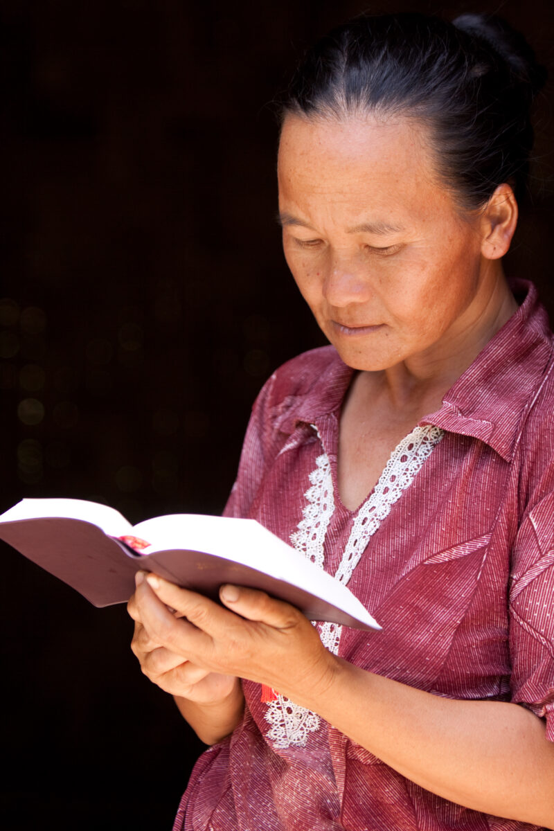 Bible Study in Laos — Woman reads the Bible in the doorway of her home in Laos — Laos, Southeast Asia, woman women, christian, ethnic
