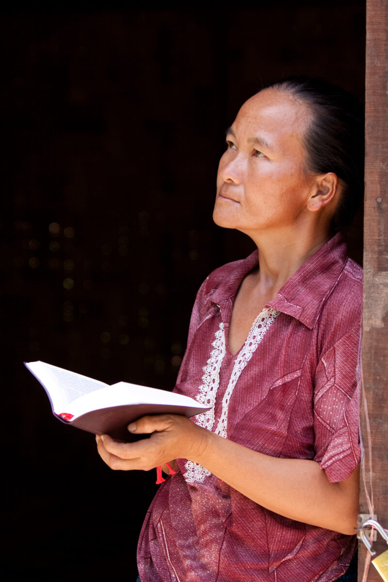 Bible Study in Laos — Woman reads the Bible in the doorway of her home in Laos — Laos, Southeast Asia, woman women, christian, ethnic