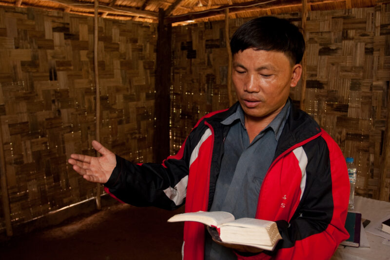 Bible Study in Laos — Ethnic Minority Pastor preaches to villagers, under the threat of persecution in the country of Laos — Laos, Southeast Asia, Christian,...