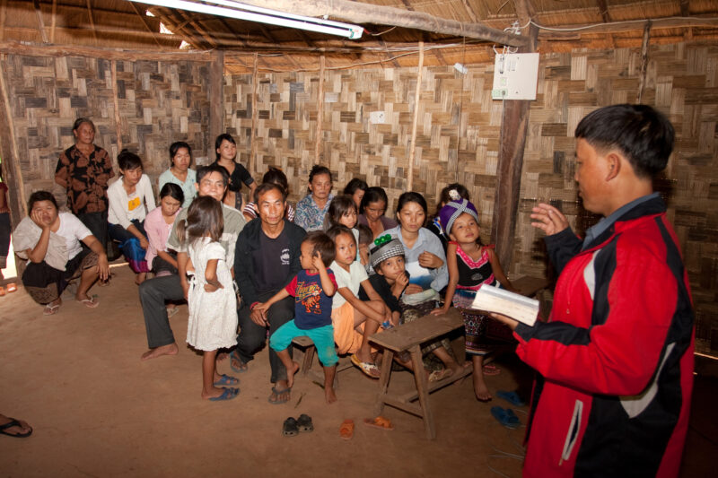 Preaching in Laos — Ethnic Minority Pastor preaches to villagers, under the threat of persecution in the country of Laos — Laos, Southeast Asia, Christian, C...