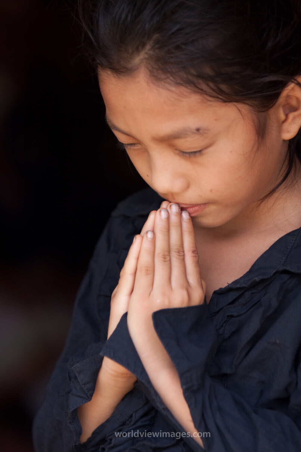 Child Prays in Laos
