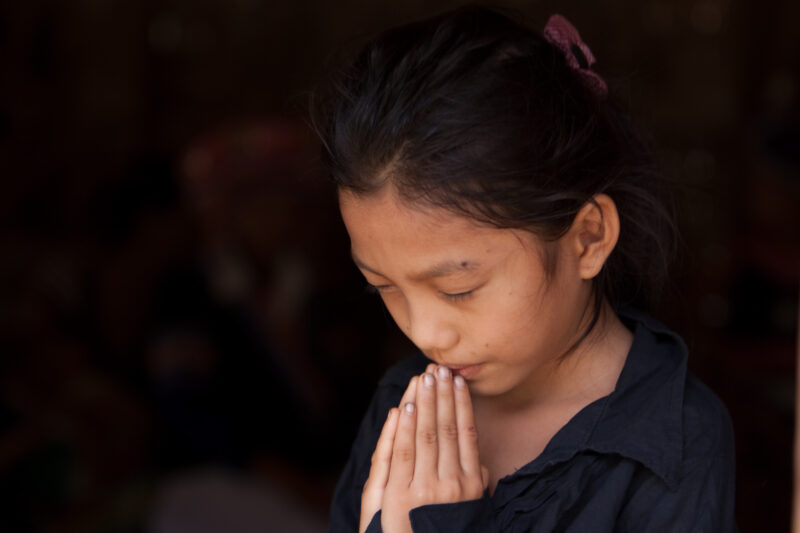 Child Prays in Laos — Ethnic girl prays, in her village in Laos — Laos, Southeast Asia, girl, child, prayer
