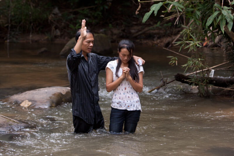 Christian Baptism in Laos — Young person becomes an Adventist Christian in the country of Laos, and is baptized in a mountian stream. — Laos, Southeast Asia,...