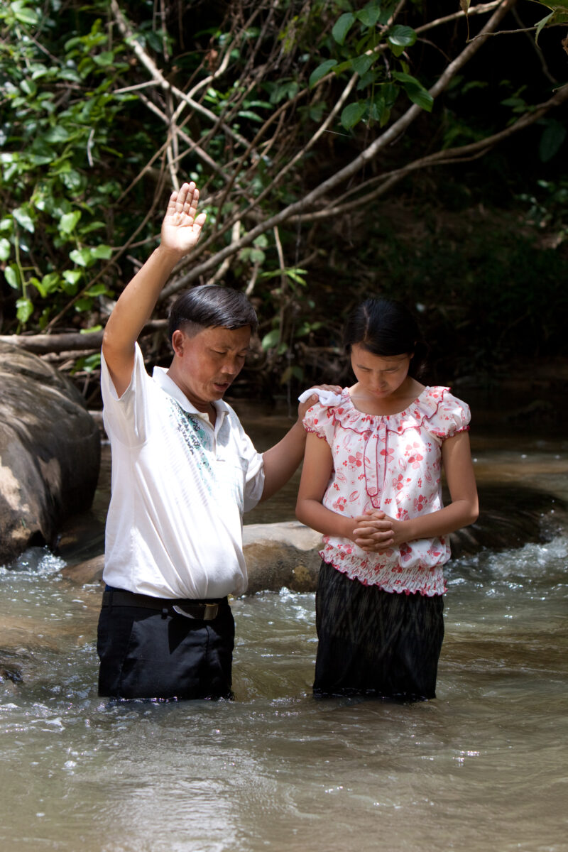 Christian Baptism in Laos — Young person becomes an Adventist Christian in the country of Laos, and is baptized in a mountian stream. — Laos, Southeast Asia,...