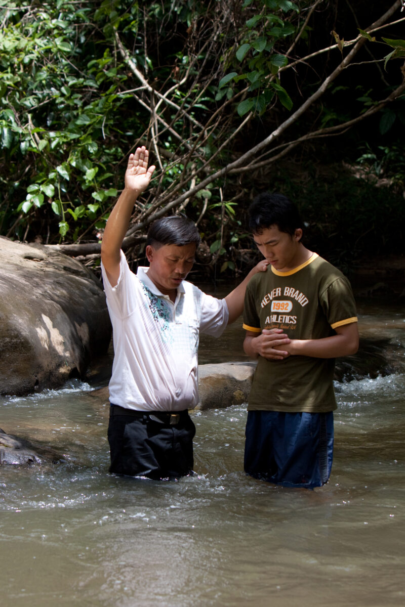 Christian Baptism in Laos — Young person becomes an Adventist Christian in the country of Laos, and is baptized in a mountian stream. — Laos, Southeast Asia,...