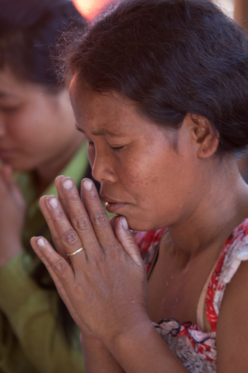 Praying in Cambodia — Seventh-day Adventist Christians in the Buddhist country of Cambodia, worship God in prayer at their simple bamboo church. — Cambodia, ...
