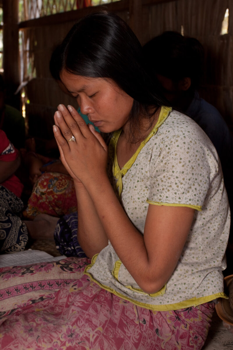 Praying in Cambodia — Seventh-day Adventist Christians in the Buddhist country of Cambodia, worship God in prayer at their simple bamboo church. — Cambodia, ...
