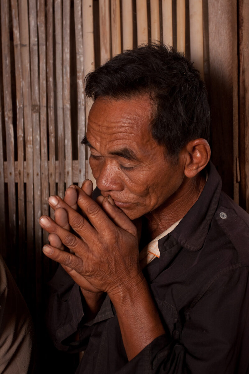 Praying in Cambodia — Seventh-day Adventist Christians in the Buddhist country of Cambodia, worship God in prayer at their simple bamboo church. — Cambodia, ...