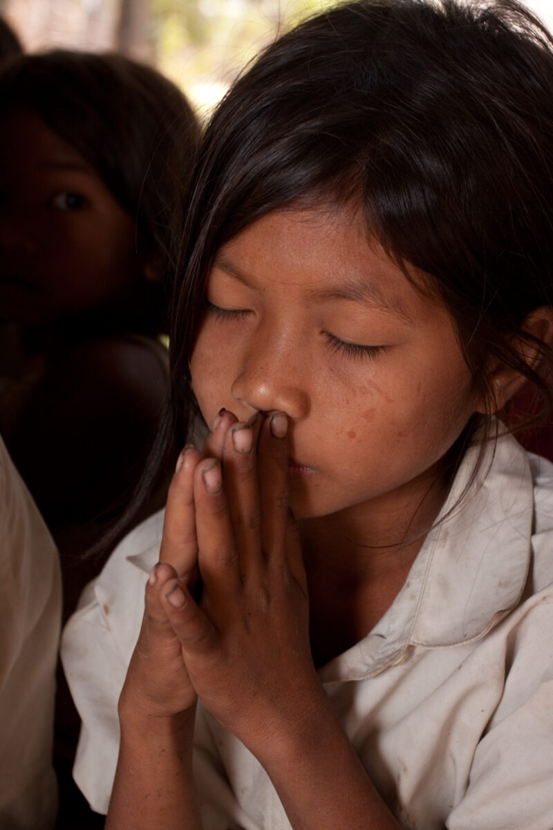 Praying in Cambodia — Seventh-day Adventist Christians in the Buddhist country of Cambodia, worship God in prayer at their simple bamboo church. — Cambodia, ...