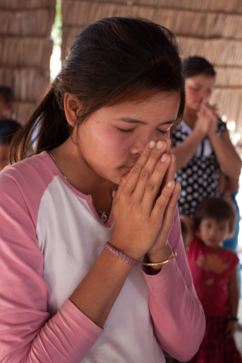 Praying in Cambodia — Seventh-day Adventist Christians in the Buddhist country of Cambodia, worship God in prayer at their simple bamboo church. — Cambodia, ...