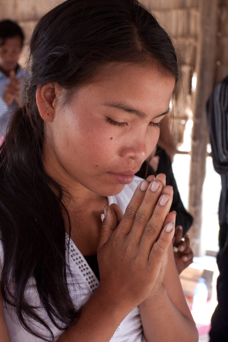 Praying in Cambodia — Seventh-day Adventist Christians in the Buddhist country of Cambodia, worship God in prayer at their simple bamboo church. — Cambodia, ...