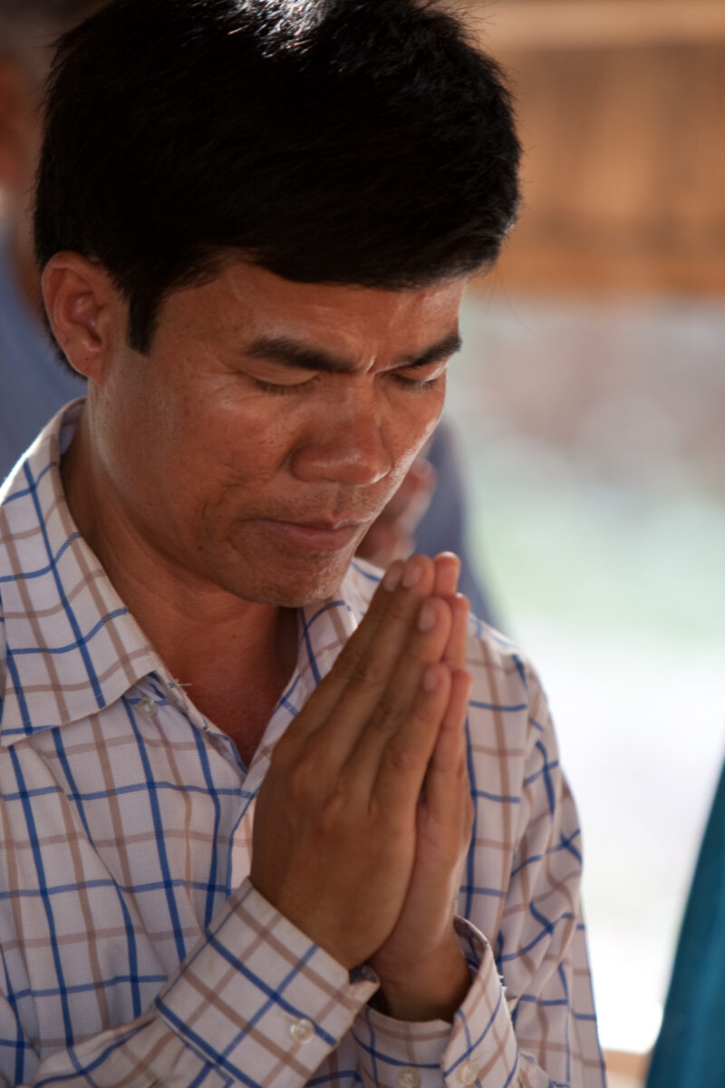Praying in Cambodia — Seventh-day Adventist Christians in the Buddhist country of Cambodia, worship God in prayer at their simple bamboo church. — Cambodia, ...