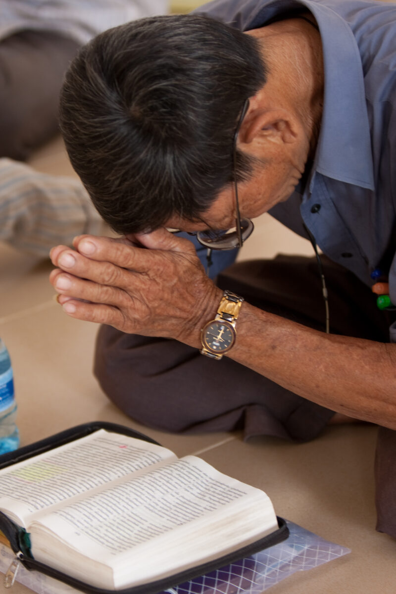 Praying in Cambodia — Seventh-day Adventist Christians in the Buddhist country of Cambodia, worship God in prayer at their simple bamboo church. — Cambodia, ...