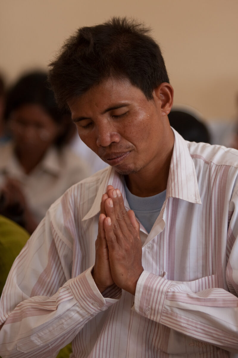 Praying in Cambodia — Seventh-day Adventist Christians in the Buddhist country of Cambodia, worship God in prayer at their simple bamboo church. — Cambodia, ...