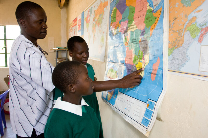 Teacher with Girls at Map — Students in the Nyburi center for disabled children learn geography at their school. — ADRA, AID, Africa, Assistance, Development