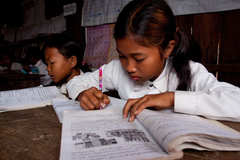 Students At Desk — Young students, now attending school in Rural Cambodia, thanks to an ADRA "reflect" program that has taught parents the value of education...