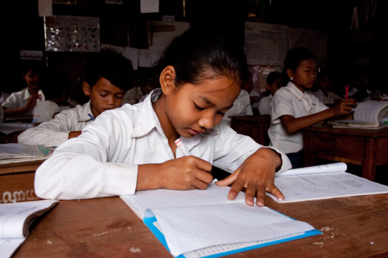 Students At Desk — Young students, now attending school in Rural Cambodia, thanks to an ADRA "reflect" program that has taught parents the value of education...