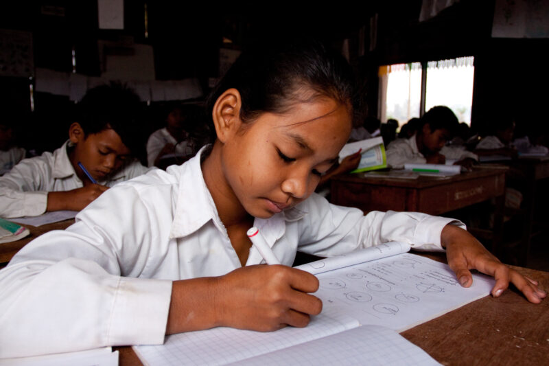 Students At Desk — Young students, now attending school in Rural Cambodia, thanks to an ADRA "reflect" program that has taught parents the value of education...