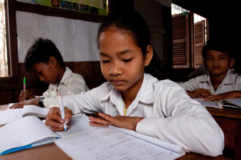 Students At Desk — Young students, now attending school in Rural Cambodia, thanks to an ADRA "reflect" program that has taught parents the value of education...