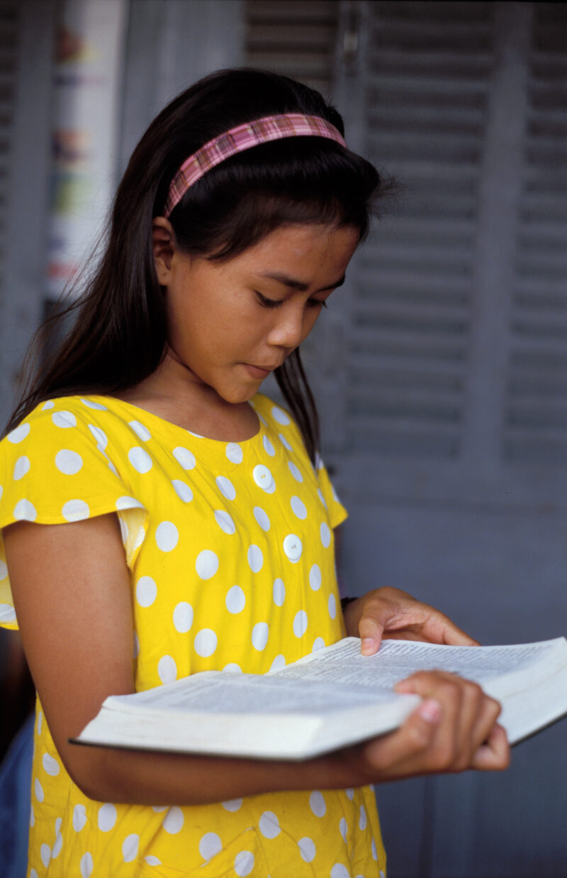 Girl in School in Cambodia — Young girl reads from a Bible at a christian School in Cambodia run by International Children's Care orphanage. — Cambodia, Scho...