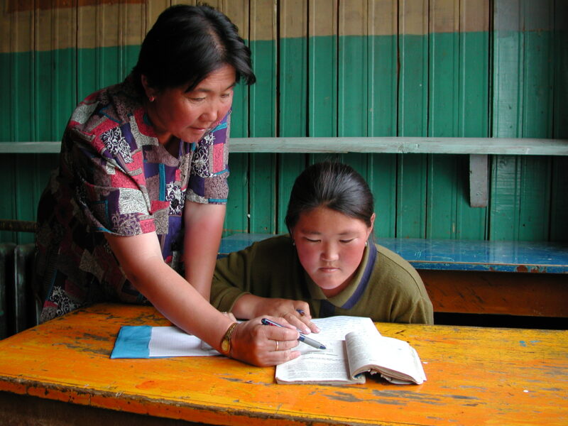 Teacher and Girl In School in Mongolia — Children of nomadic herders in Mongolia make up for education that they have missed, in a special summer school prog...