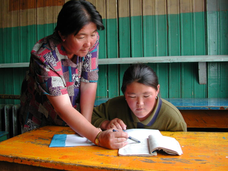 Teacher and Girl In School in Mongolia — Children of nomadic herders in Mongolia make up for education that they have missed, in a special summer school prog...