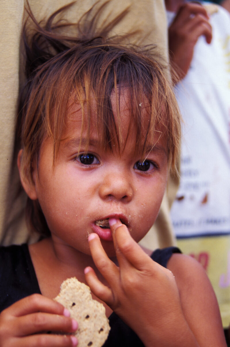 Eating in Cambodia — Children who have been displaced by a volcano erupting in the Philipines, eat food that has been given to them in an emergency food dist...