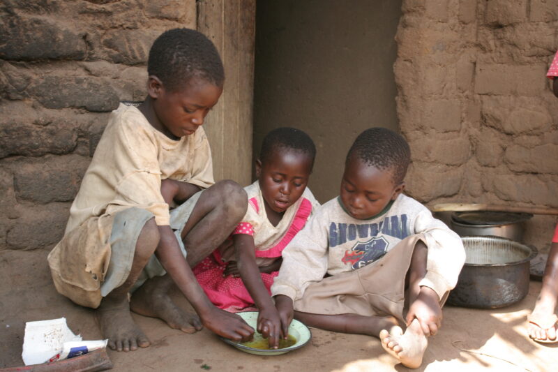 Eating a Simple Meal in Malawi — Poor Children in Malawi share a simple meal of greens thay have picked in the field — Malawi, Africa