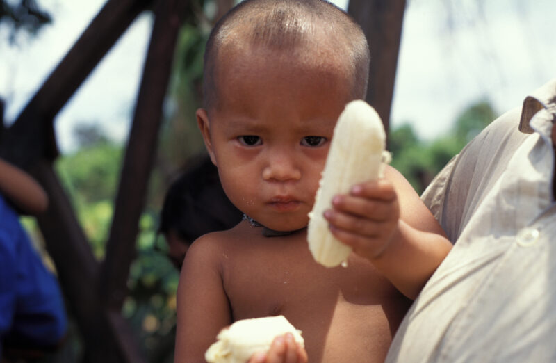 Eating in Cambodia — Poor children in Cambodia eat bananas they have just received in an emergency food distribuion. — Cambodia. children, child, eating, foo...