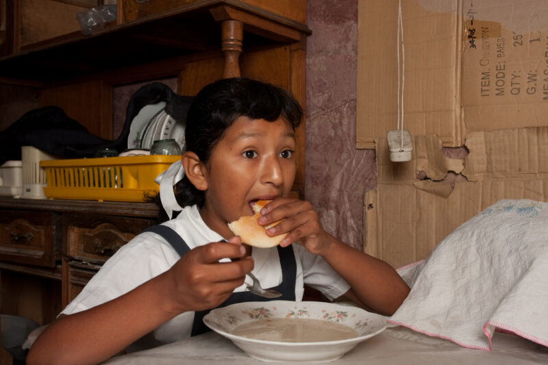 Eating Meal in Peru — Poor girl, living in poverty in a shantytown on the outskirts of Lima, eats a simple meal. — Peru, girl, child, food, meal