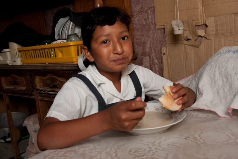 Eating Meal in Peru — Poor girl, living in poverty in a shantytown on the outskirts of Lima, eats a simple meal. — Peru, girl, child, food, meal