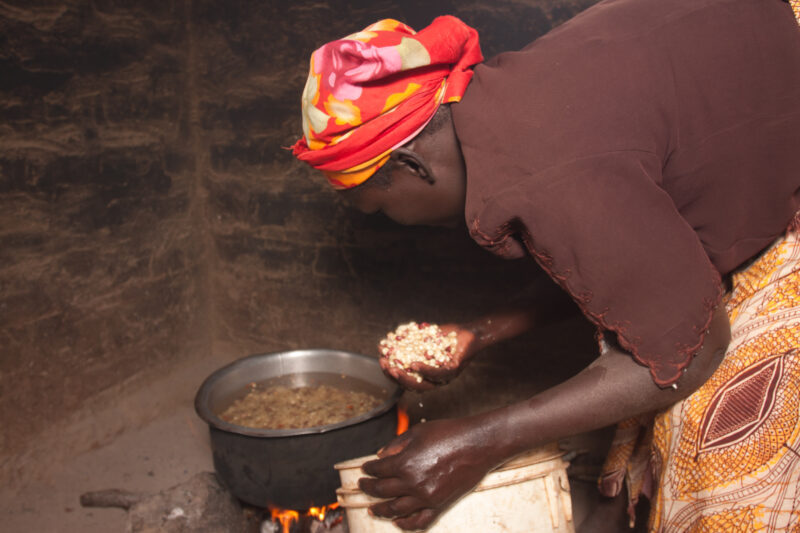 Cooking Maize — Kenyan woman cooks maize over an open fire in her kitchen — Africa, Kenya, African, Woman, cooking