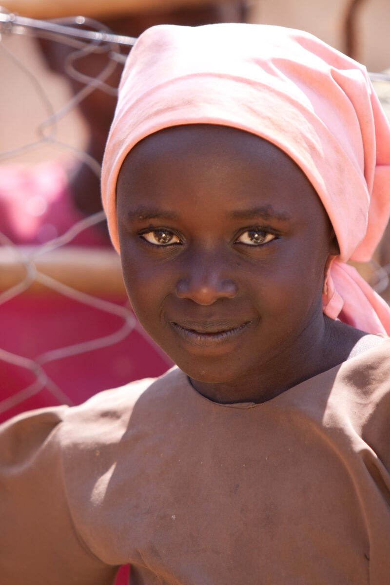 Girl inKenya — Girl smiles for camera in spite of her hunger from the drought that has hit her part of Kenya, Africa — Kenya, drought, girl, girls, faces