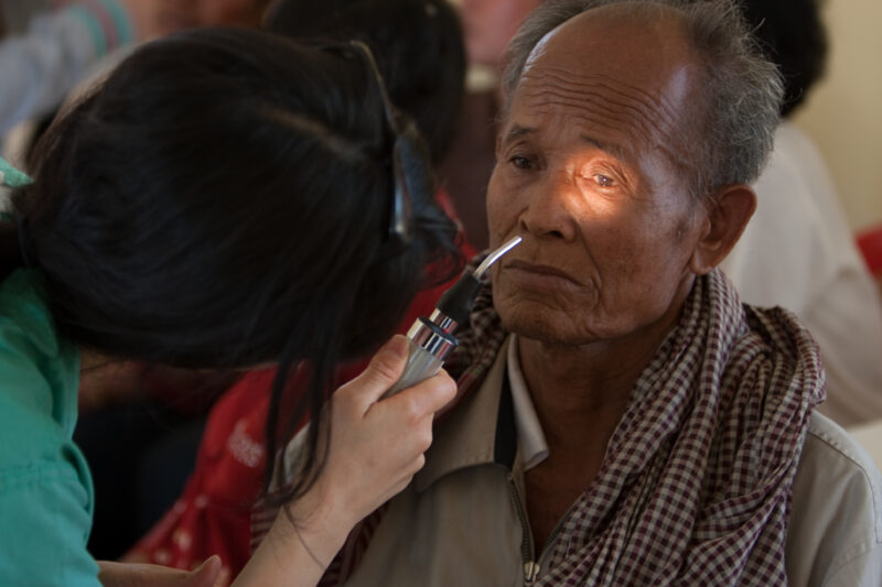Eye Exam in Cambodia — Man gets a free Eye exam at a clinic in Cambodia supported by a volunteer group from the US — Cambodia, health, eye, eyes, exam