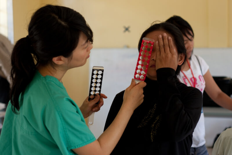 Eye Exam in Cambodia — Man gets a free Eye exam at a clinic in Cambodia supported by a volunteer group from the US — Cambodia, health, eye, eyes, exam
