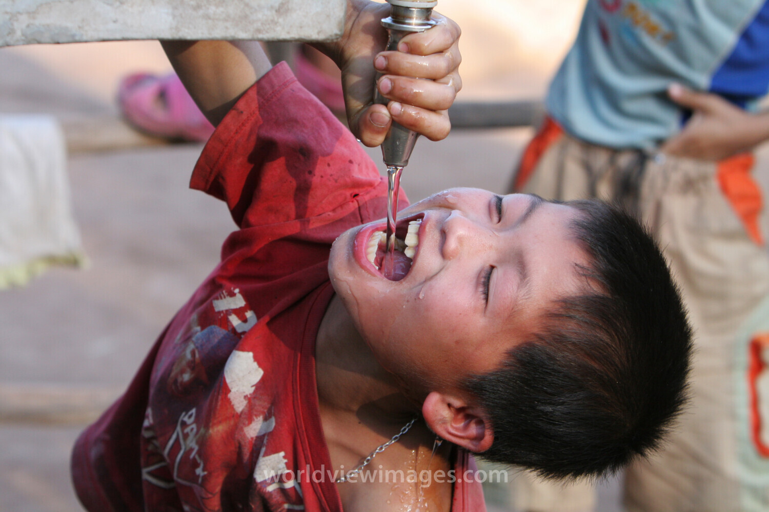Boy gets water in Laos