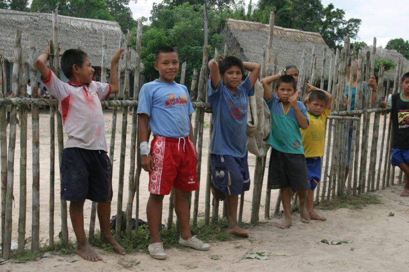 Children in Shipibo Village in Peru — Stock Image of Shipibo Children standing by fence in their village on the Ucayali River — Peru, ADRA, Poverty, Developm...