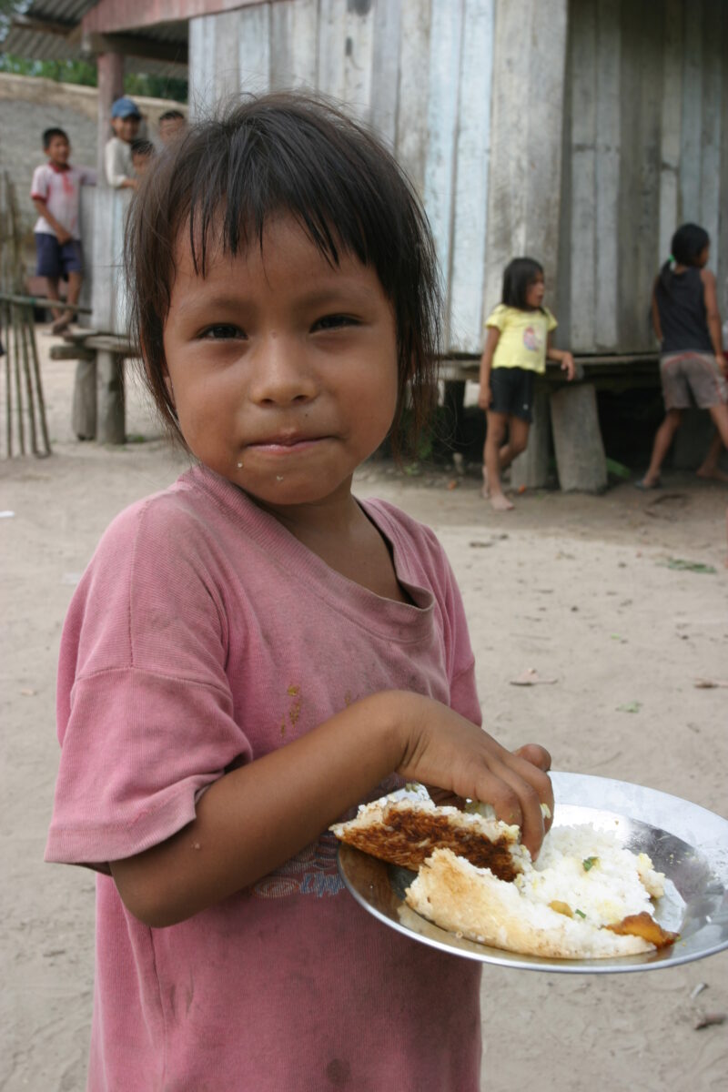 Shipibo Girl inPeru — Shipibo Ethnic girl easts Cassava and rice in her village in Peru — Peru, Shipibo, Amerindian, village, girl