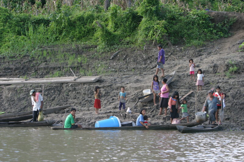 On the Banks of the Ucayali River in Peru — Villagers come and go in their dugout canoes at their village on the Ucayali River. — Ethnic Minority, Shipibo In...