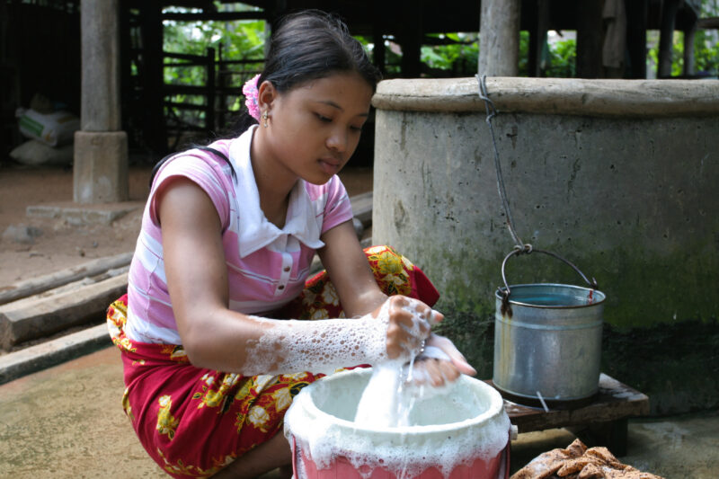 Washing Clothes in Cambodia — Girl uses water from a ADRA well to wash clothes for her family — Cambodia, girl, water, water Uses, laundry