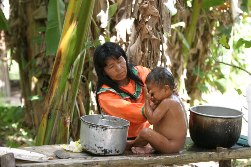 Bathing Baby in Peru — Shipibo woman washes her baby with water from the well — ADRA, Peru, Poverty, Shipibo Indians, Ucayali River