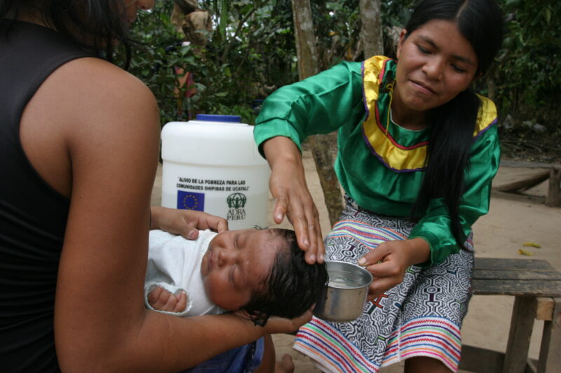 Bathing Baby in Peru — Shipibo woman washes her baby with water from the well ADRA helped install in her village. — Peru, ADRA, water, washing, baby