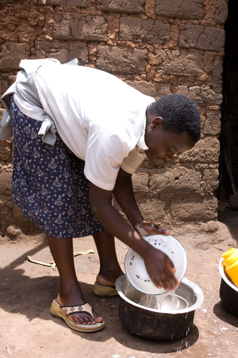 Washing Dishes in Rwanda — Girl uses water to wash the family dishes in Rwanda — Africa, Rwanda, girl, washing dishes